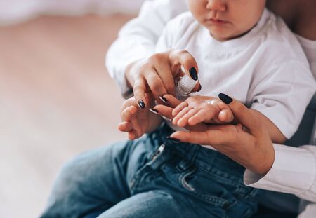 Mom with a child rubs their hands with a sanitizerの写真素材