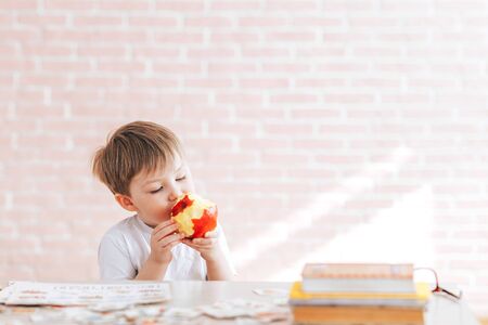 Beautiful little boy eats an appleの写真素材