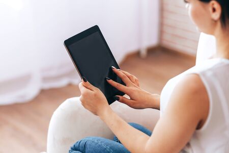 Young girl sitting in chair with tablet