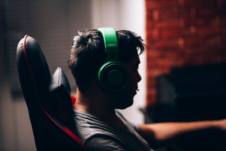 computer games, playing place, young gamer plays computer games with headphones,の写真素材