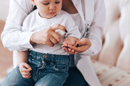 Mom with a child rubs their hands with a sanitizerの写真素材