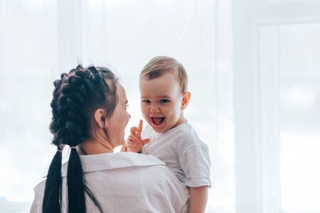 Young mother holding little son in her armsの写真素材