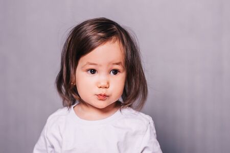 Little girl with her hair and in a white T-shirtの写真素材