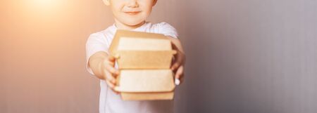 Beautiful little boy holding boxes in handsの写真素材