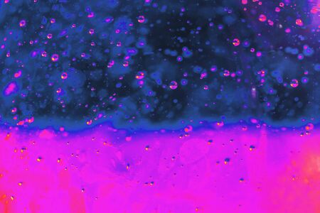 Lot of small bubbles on an blue pink background, macro shot of liquid soap, macro shot of cocktail with fruit juice, neon.の写真素材