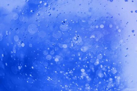 Lot of small bubbles on an blue background, macro shot of liquid soap, macro shot of glass with beer, macro shot of cocktail with fruit juice.の写真素材