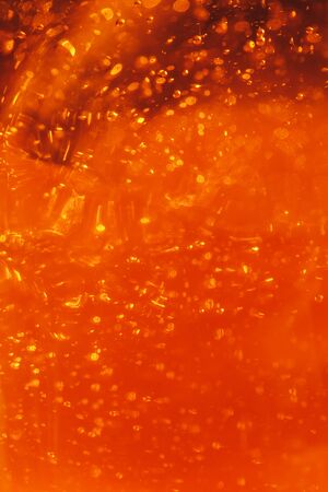 Lot of small bubbles on an orange background, macro shot of liquid soap, macro shot of glass with beer, macro shot of cocktail with fruit juiceの写真素材