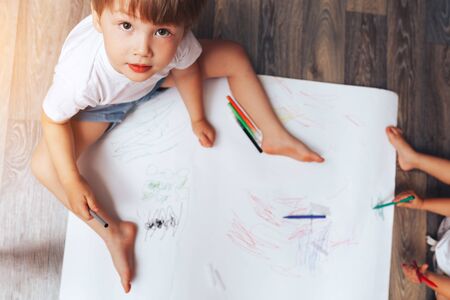 Talented children draw with colored felt-tip pens on white paper, lessons, tasks with children of the different ages.の写真素材
