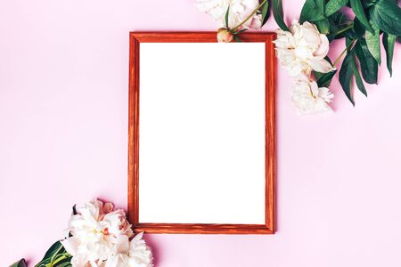 Beautiful delicate peonies and portrait frame on a pink background, blooming flowers, March 8, mother's day, birthday present.の写真素材
