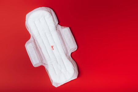 sanitary napkin with red balls imitating menstruation on a red background, health care, monthly protection, reliable friendの写真素材
