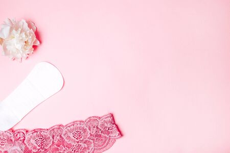 sanitary napkin with a beautiful peony and underwear on a pink background, health care, monthly protection, reliable friend.の写真素材