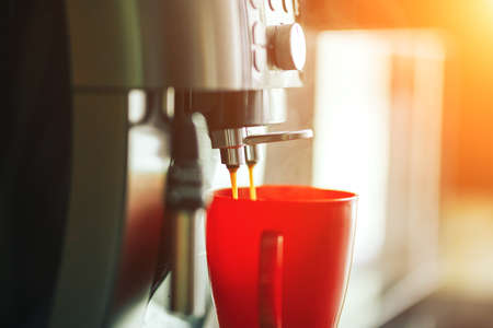 Close-up coffee machine making fresh coffee in the morning, coffee machine and red mug.の写真素材