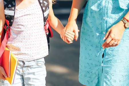 Mom holding her child s hand, mom meets her child from school, back to school.の写真素材