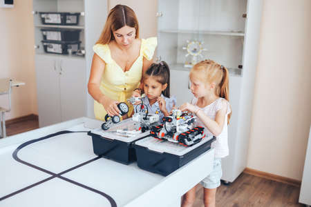 Two schoolgirls study in a robotics class, assemble a robot constructor.の写真素材
