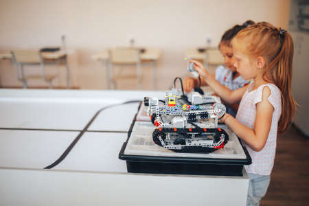 Two schoolgirls study in a robotics class, assemble a robot constructor.の写真素材