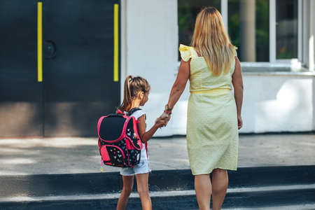 Mom holding the hand of her child, mom escorts her child to school, back to school, knowledge day.の写真素材