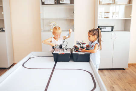 Two schoolgirls study in a robotics class, assemble a robot constructor.の写真素材