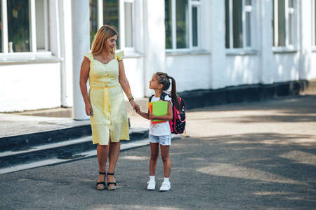 Mom holding her child s hand, mom meets her child from school, back to school.の写真素材