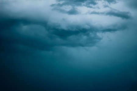 Dark and eerie clouds floating across the sky, storm clouds in the dark.