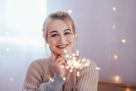 Young girl holding a sparkler in her hands is very happy about the arrival of Christmas, Merry Christmas and Happy New Year.の写真素材
