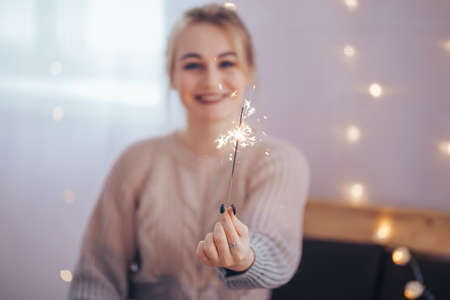 Young girl holding a sparkler in her hands is very happy about the arrival of Christmas, Merry Christmas and Happy New Yearの写真素材