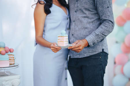 Young couple are hugging and holding a plate with a piece of cake