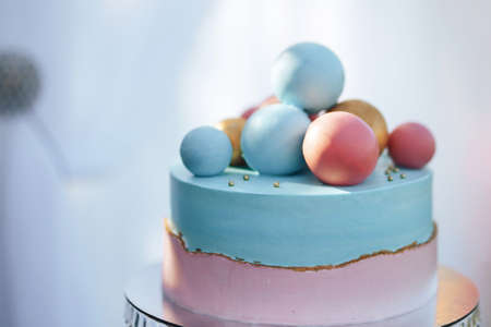 Two-tier cake is two-tone, the bottom of the cake is pink and the top is blue, the cake has different balls.の写真素材