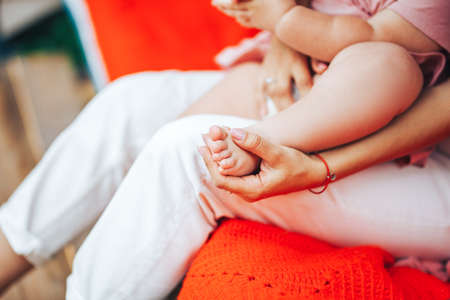 A child is sitting in the arms of an adult, taking care of children.の写真素材