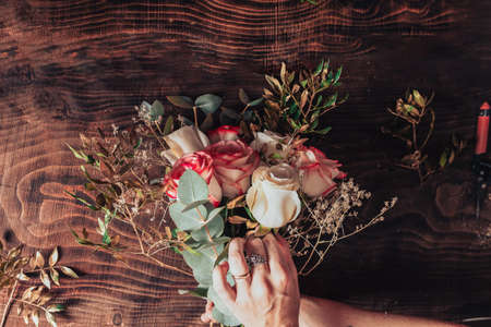 Making a beautiful bouquet of flowers from different types of flowers, a hand-made gift for a loved one or for a bossの写真素材