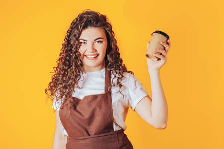 Woman holding a cup of hot coffee in her hands. Coffee shop advertisement. Place for your text.の写真素材