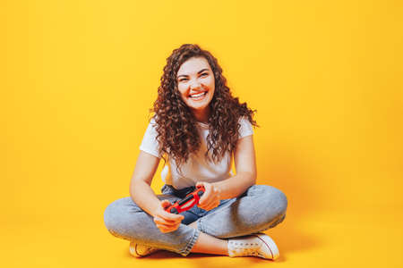 Beautiful young woman playing video games while holding a game controller. Woman in eSports. Place for text.の写真素材