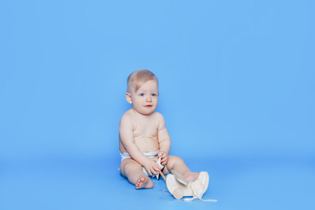 Little boy sits in front of a blue background. Care for children. Adoption of children. Artificial insemination.の写真素材