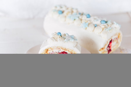 A cut piece from a white roll cake with a cherry filling on against a white background. Christmas mood. Sweets for any occasion.の写真素材