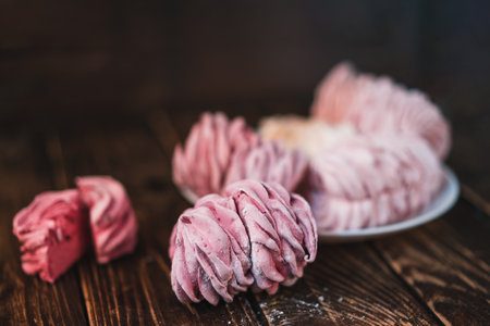 Appetizing multi-colored marshmallow on a plate on a wooden table. Tea drinking concept. Confectionery decoration. Place for textの写真素材