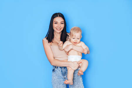Mom plays in her arms with her son against a blue background. Education and care for the health of...