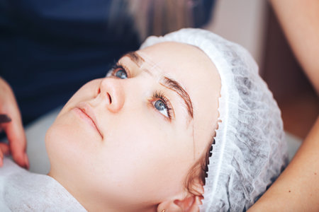 Cosmetolog beauty master making marks before the permanent makeup procedureの写真素材
