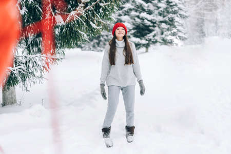 Woman with red heart-shaped balloons. Romantic mood on the background of a snowy park.
