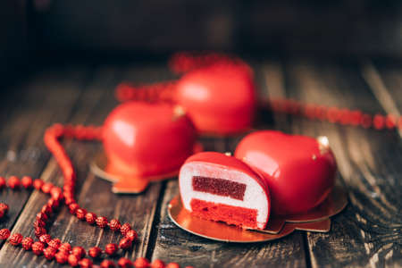 Red heart-shaped cake and red beads. Gift for Valentine's Day and Women's Day.の写真素材
