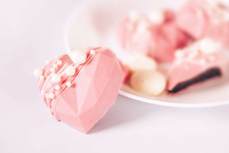 Pink heart-shaped cake on a plate. Gift for Valentine's Day and Women's Day.