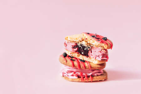 Heart shaped cakes against pink background, the top cookie is broken. Homemade cakes for holiday, party and gift to your loved one.の写真素材