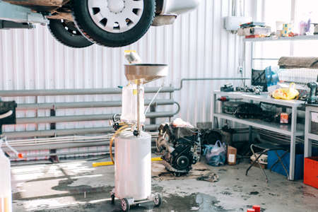 Car lifted on car lift for routine maintenance.
