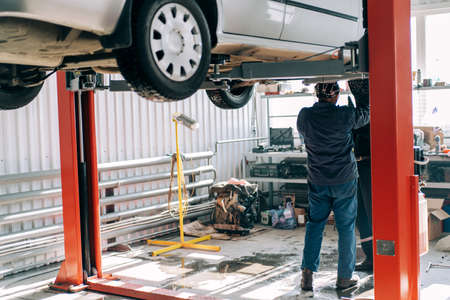 Professional mechanic repairs an internal combustion engine and changes the oil. Service station worker.の写真素材