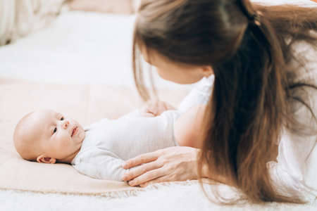 Young mother plays and talks with her newborn baby. Love and care for children. Adoption of...