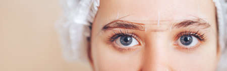 Cosmetolog beauty master making marks before the permanent makeup procedureの写真素材