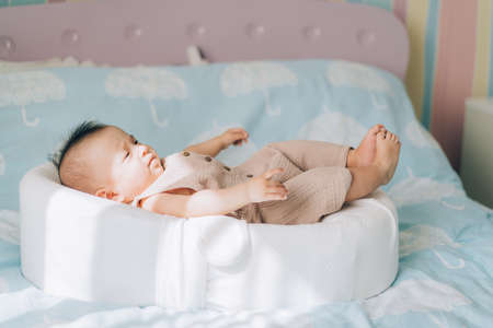 Asian child lying on the bed. Caring for newborn children.