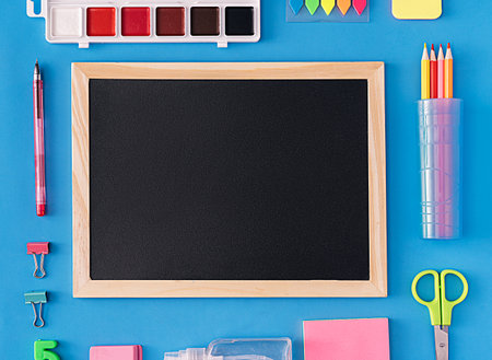 Around school chalkboard school supplies on blue background.の写真素材