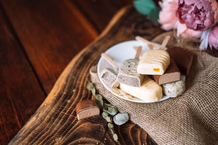Still life of chocolate popsicle lying on a plate on a wooden tableの写真素材