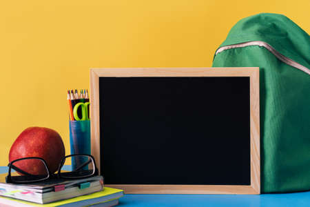 School supplies and chalk board on blue background.の写真素材