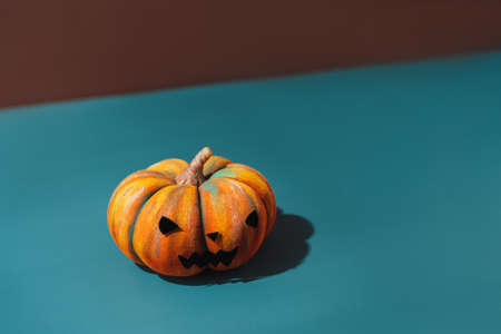 Pumpkin with an evil face on blue background.