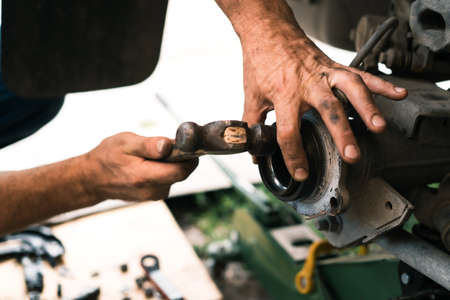 Auto mechanic repairing the brake system of car.